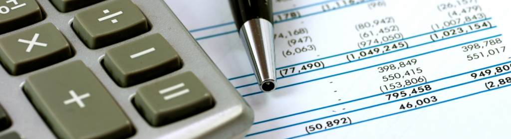 Calcular o orçamento de obra com uma calculadora e uma caneta sobre uma planilha financeira, destacando a importância do planejamento financeiro na construção civil.