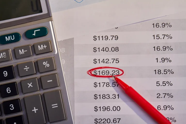 Imagem de uma calculadora ao lado de um extrato financeiro que destaca um valor de $169.23, ilustrando o conceito de split payment em análise financeira