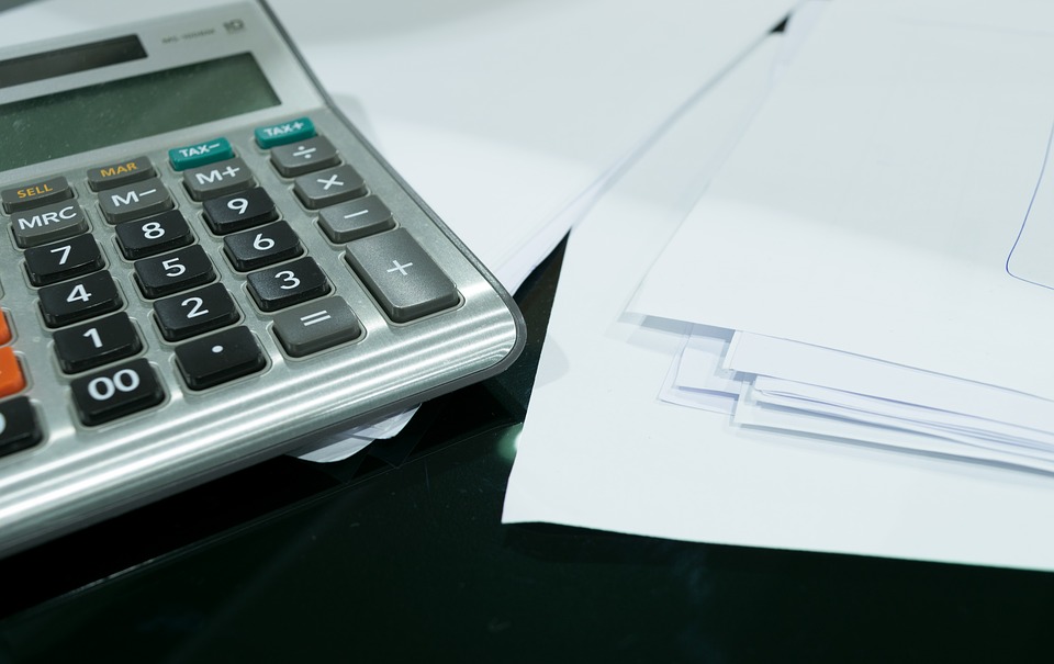 notas fiscais: imagem mostra diversas folhas de papel em branco e uma calculadora